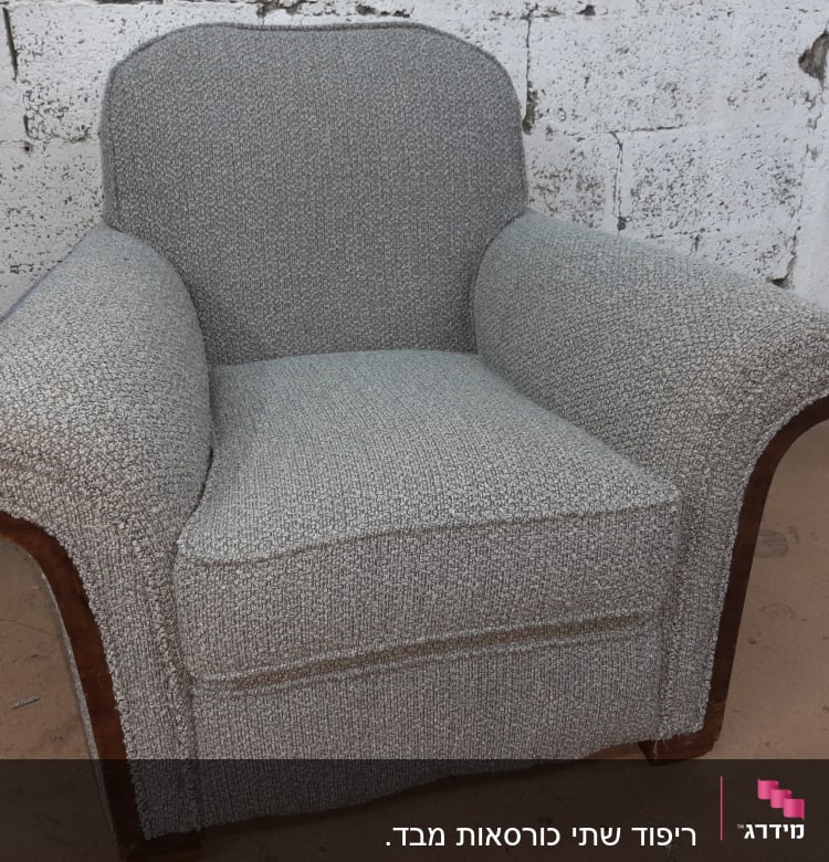 כורסה מרופדת בבד אפור עם מסגרת עץ